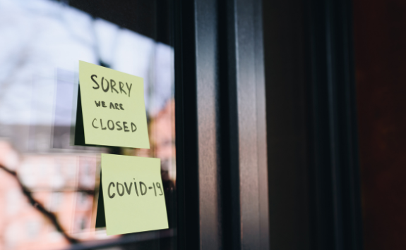 A sign on a door of a shop reads: We are closed due to COVID-19	